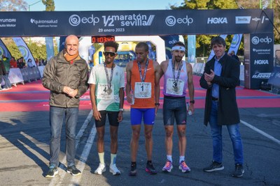 El alcalde Antonio Muñoz y el delegado de Transición Ecológica y Deportes del Ayuntamiento de Sevilla, David Guevara, junto a los tres primeros clasificados masculinos.